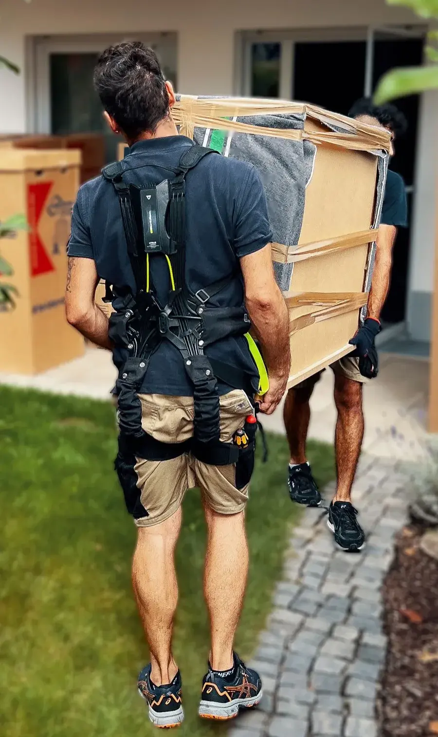 Umzugshelfer trägt schwere Möbel mit hTRIUS BionicBack Exoskelett